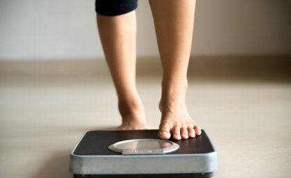 People with schizophrenia often stop taking prescribed medications because of weight gain. Image: Adobe. A woman's lower legs stepping onto weighing scales.